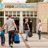 Menschen mit Taschen gehen auf den Eingang des Copa Ca Backum zu.
