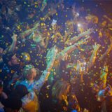 Menschen tanzen auf einer Party, goldenes Konfetti regnet auf sie herab.