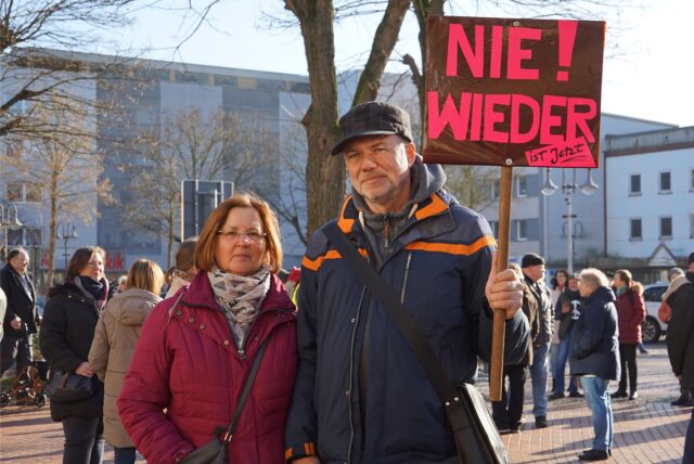 Ein Paar steht auf dem Berliner Platz in Oer-Erkenschwick und hält ein Plakat mit den Worten „Nie wieder!“ hoch.