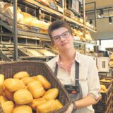 Eine Bäckereiverkäuferin steht in einer Bäckerei in Datteln und hält einen Korb mit Brötchen in den Händen. (Archivbild)