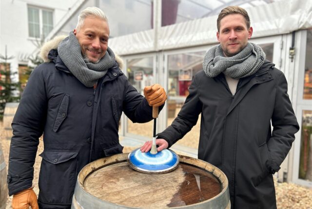 Sven Hecker und Andre Schult vom 1. Asphalt- und Eisstock Verein in Dorsten halten zusammen einen Eisstock auf dem Winterzauber.