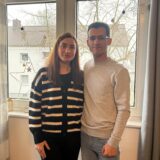 Eine Frau und ein Mann stehen in einem Wohnzimmer in ihrer Wohnung in Datteln. Sie stehen vor einer Fensterscheibe, an der eine Kette mit Sternen hängt.