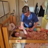 Schwester Moira Schulz versorgt in der Kinderklinik Datteln ein kleines Mädchen im Krankenbett.