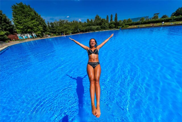 Eine Frau springt im Freibad in Deusen ins Becken.