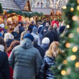 Menschen gegen durch die weihnachtlich geschmückte Innenstadt.