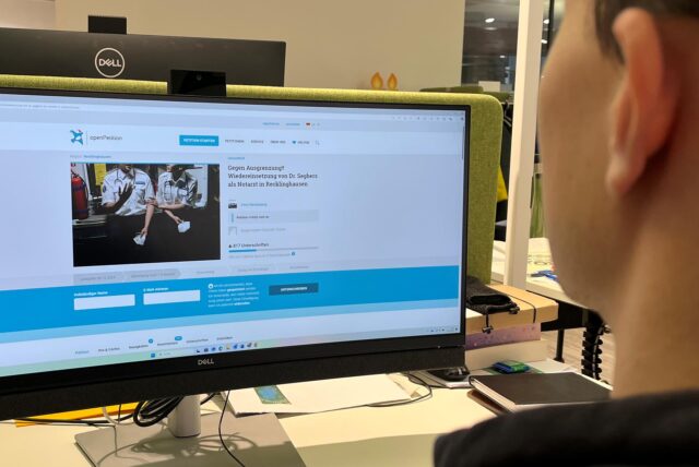 Eine Person sitzt vor einem Computer und hat eine Online-Petition aufgerufen.