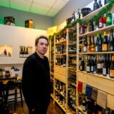 Pascal Hermeler steht in seinem Weinhandel „The Tasting Room“ in Recklinghausen vor einem gefüllten Weinregal.