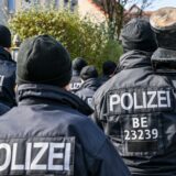 Beamte eines Spezialeinsatzkommandos sind von hinten zu sehen. Sie tragen Mützen. Einer hat eine Türramme geschultert.