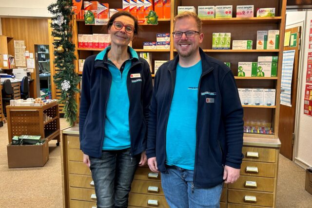 Dr. Lucia Wolf-Krowartz und David Ruf stehen in der Greif-Apotheke vor dem Tresen.