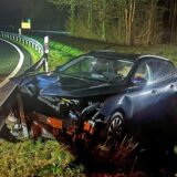 Ein im Frontbereich zerstörtes Auto steht an einer Leitplanke.