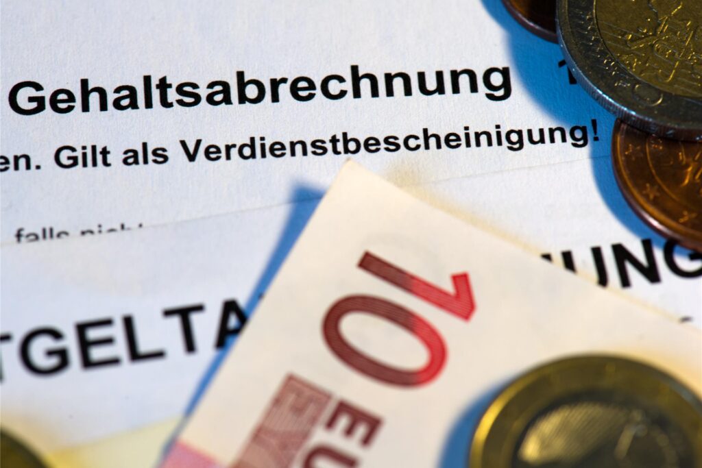 Geld liegt auf einer Gehaltsabrechnung.