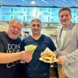 Thomas Frauendienst überreicht die ersten Hundert-Euro-Scheine an Selam Tasdemir, während sich Michael Breilmann von der Döner-Qulität überzeugt.