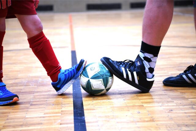 Fußball/Breitensport, 18. Dezember 2024; Ein Junge und ein Erwachsener stoppen einen Fußball (Feature; zur Reportage: Führungszeugnis für Übungsleiter)