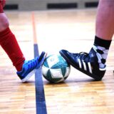 Fußball/Breitensport, 18. Dezember 2024; Ein Junge und ein Erwachsener stoppen einen Fußball (Feature; zur Reportage: Führungszeugnis für Übungsleiter)