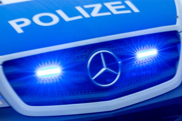 Im Kühlergrill eines Polizei-Einsatzfahrzeugs leuchtet links und rechts des Mercedes-Sterns Blaulicht.