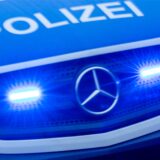 Im Kühlergrill eines Polizei-Einsatzfahrzeugs leuchtet links und rechts des Mercedes-Sterns Blaulicht.