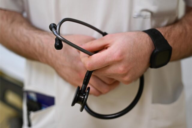 Lars Alles, Assistenzarzt für Innere Medizin, hält in der Notaufnahme des Kreiskrankenhauses Alsfeld ein Stethoskop in den Händen.