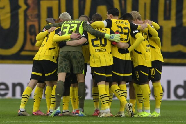 Die BVB-Spieler stehen in einem Kreis zusammen.