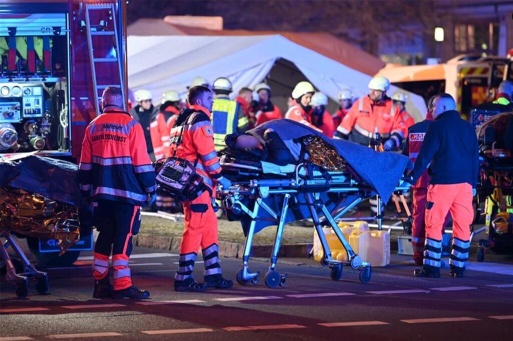 Viele Einsatzkräfte, eine Person wird auf einer Trage weggeschoben. Viele Einsatzkräfte, eine Person wird auf einer Trage weggeschoben.