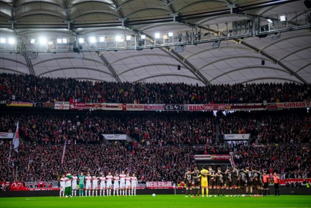 Die Spieler des VfB Stuttgart und St. Pauli stehen vor dem Spiel bei einer Schweigeminute für die Opfer der Attacke auf dem Magdeburger Weihnachtsmarkt zusammen.