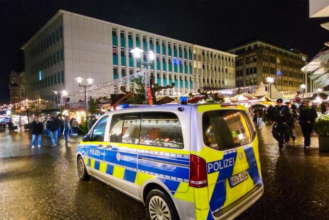 Ein Einsatzwagen der Polizei steht am Rand des Altstadtmarktes in Recklinghausen. Dahinter ist der Weihnachtsmarkt zu sehen.
