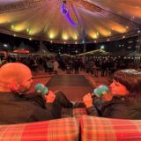 Im PottCAS Folge 122 saß unser Team auf der Bühne im Castroper Weihnachtsdorf. Hier spricht die Gründerin unseres Podcasts, Nora Varga (r.), mit dem aktuellen Host Luca Füllgraf über die unfassbarste Kneipen-Story des Jahres.