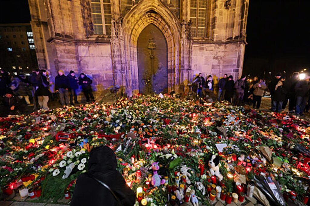 Menschen legen Blumen und Kerzen am offiziellen Gedenkort an der Johanniskirche nieder. Menschen legen Blumen und Kerzen am offiziellen Gedenkort an der Johanniskirche nieder.