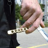 Eine Hand hält ein halb ausgeklapptes Butterfly-Messer fest.