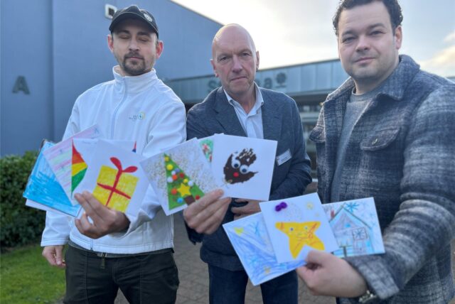 Julian Krupka (links) und Patrick Schürhoff (rechts) von der Deutschen Haushaltshilfe übergeben selbstgebastelte Weihnachtskarten von Kita- und Grundschulkindern an Markus Loth, Leiter des Alten- und Pflegeheims St. Anna in Dorsten.