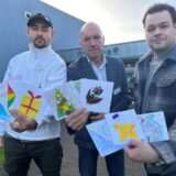 Julian Krupka (links) und Patrick Schürhoff (rechts) von der Deutschen Haushaltshilfe übergeben selbstgebastelte Weihnachtskarten von Kita- und Grundschulkindern an Markus Loth, Leiter des Alten- und Pflegeheims St. Anna in Dorsten.