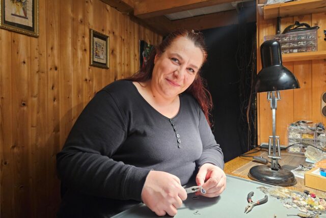 Verena Rochowski fertigt mit einer Zange in der Hand einen Ohrring.
