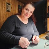 Verena Rochowski fertigt mit einer Zange in der Hand einen Ohrring.