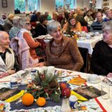 Drei Frauen beim Gespräch an einem weihnachtlich gedeckten Tisch im Wichernhaus in Castrop.