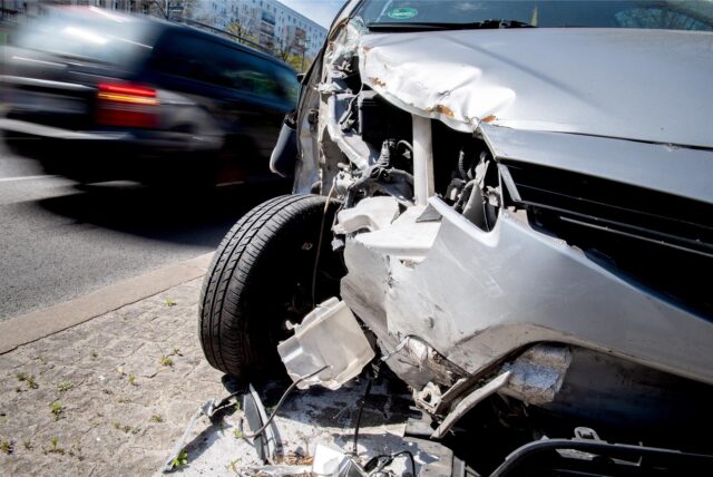 Ein Auto hat nach einem Unfall eine beschädigte Motorhaube.