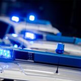 Drei Polizeifahrzeuge mit eingeschaltetem Blaulicht.