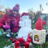 Wetterexperte Burkhard Dreischer hockt in seinem Garten in Dortmund neben einem Schneemann.