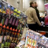 Silvesterraketenpackugen und zwei Menschen im Hintergrund.