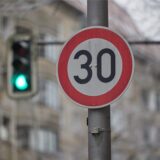 Ein Tempo-30-Schild an einer Kreuzung, im Hintergrund eine grüne Ampel