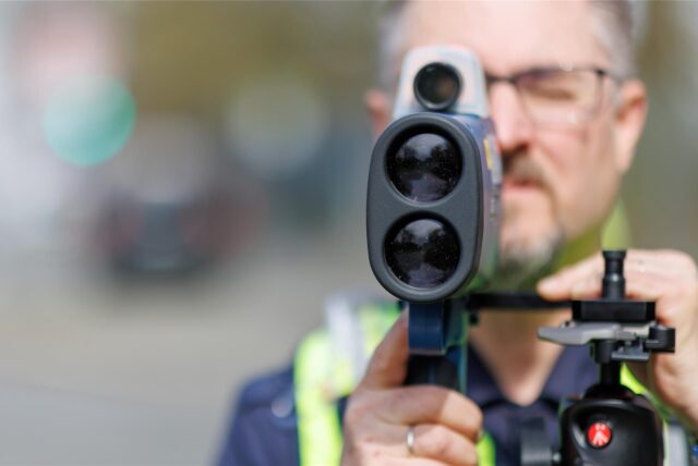 Ein Polizist bei einer Geschwindigkeitsmessung.
