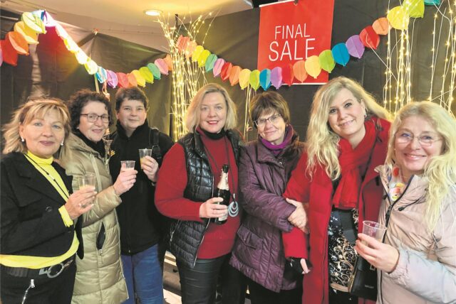 Conny Winselmann (l.) und Doris Grundfeld (M.) sagen ihren Kundinnen mit Sekt lebwohl.