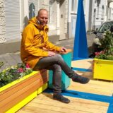 Ein Mann und eine Frau sitzen auf sogenannten Stadtmöbeln.