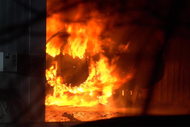Einsatzkräfte der Bochumer Feuerwehr stehen in Bochum-Langendreer vor einer Lagerhalle, an der ein Großbrand ausgebrochen war.