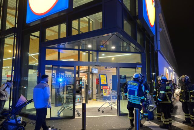 Feuerwehrleute und Blaulicht vor dem Lidl-Markt bei Nacht