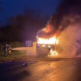 Zwei Feuerwehrleute halten einen Schlauch, aus dem Löschwasser in Richtung eines brennenden Lkw schießt.