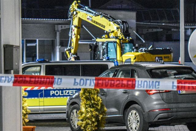 Ein Bagger steht nach einer mutmaßlichen Amokfahrt neben einem Autohaus in Tauberbischofsheim.