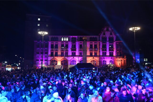 Viele Menschen stehen an Silvester vor dem Dortmunder Rathaus, um zu feiern.