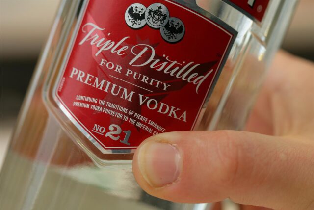 Eine Hand hält eine Wodka-Flasche.