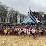 Der Startschuss zum Bad im Stausee ist gefallen, alle stürmen über den Strand.