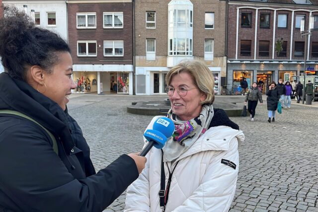 DZ-Reporterin Janina Preuß steht auf dem Marktplatz in Dorsten und interviewt eine Bürgerin.