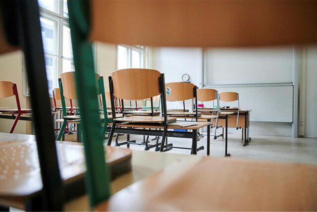 Leerer Klassenraum mit hochgestellten Stühlen